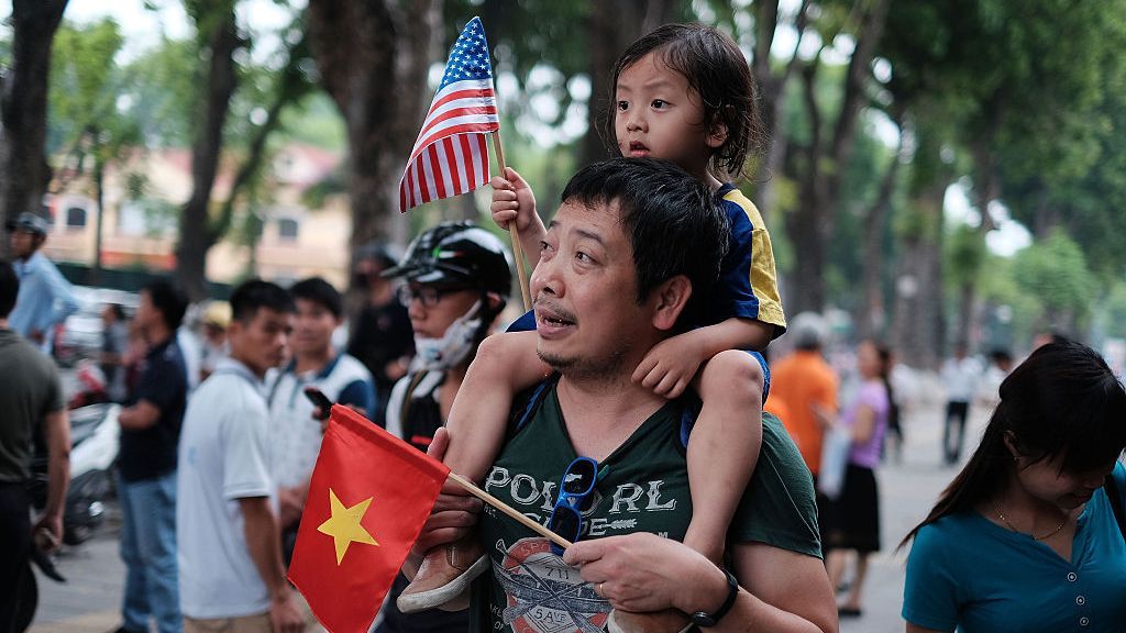 A man carries his daughter near Vietnam's presidential palace in Hanoi as then-President Barack.Obama began a three-day visit to the country in May 2016. (Linh Pham/Getty Images)