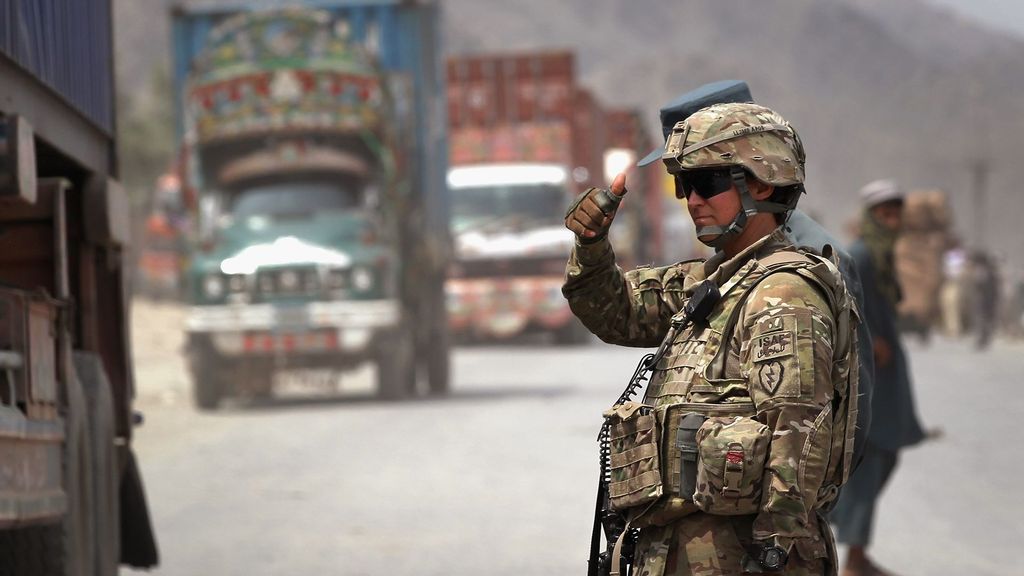 U.S. Army Spc. Laurianne Lau from Stockton, CA, allows a convoy to pass while directing traffic at the border crossing between Afghanistan and Pakistan August 27, 2011, at Torkham, Afghanistan. (John Moore/Getty Images)