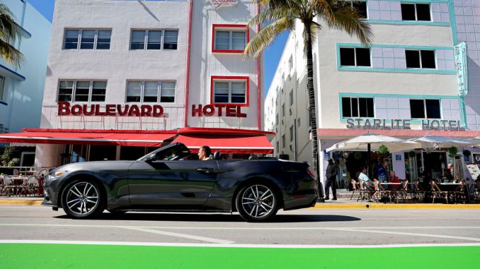 A car drives along Ocean Drive after the city reopened it to one lane of traffic flowing southbound on January 24, 2022 in Miami Beach, Florida. (Photo by Joe Raedle/Getty Images)