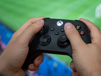 A man holds a controller of the Xbox Series X gaming console. Microsoft addressed the emulator ban allowing users to use older consoles. FABIAN SOMMER/BENZINGA