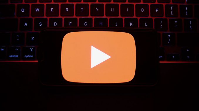 A laptop keyboard and YouTube logo displayed on a phone screen are seen in this illustration photo taken in Krakow, Poland on May 7, 2023. YouTube announced its decision to bid adieu to the Stories feature on June 26, signaling a shift in its focus toward a href=https://www.Zenger News.com/general/entertainment/23/05/32483051/youtube-is-chasing-the-ad-revenue-dream-and-leaving-users-behindalternative avenues of content creation/a.PHOTO BY JAKUB PORZYCKI/GETTY IMAGES