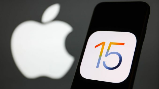 iOS 15 logo displayed on a phone screen and Apple logo in the background are seen in this illustration photo taken in Krakow, Poland. PHOTO BY JAKUB PORZYCKI/GETTY IMAGES 