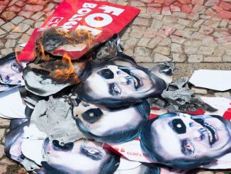 Masks with the altered image of Brazilian President Jair Bosonaro are burned during a protest about government measures to handle the COVID-19 pandemic on Oct. 20, in Brasilia, Brazil. The country’s Senate is currently looking into the government’s role in mismanaging the response to the virus. (Photo by Andressa Anholete/Getty Images)