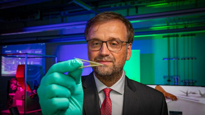 Oliver G. Schmidt is seen holding flexible microelectronics that can be fitted with many of the tiny batteries he and his research team helped develop. (Jacob Muller/Zenger)