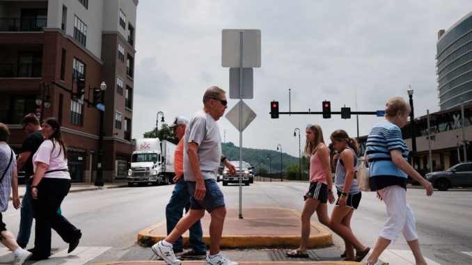 People walk down the street in Branson, Missouri. Researchers have discovered that people's childhood experiences of navigating their environments, whether urban or rural, determine their sense of direction in later years. (Spencer Platt/Getty Images)