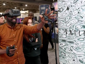 An attendee tries the virtual reality demonstration setup in the AEXLAB booth during the DCentral Miami Conference in November 2021 in Miami, Florida. Such systems are part of the fast-growing physical/digital metaverse. (Joe Raedle/Getty Images)