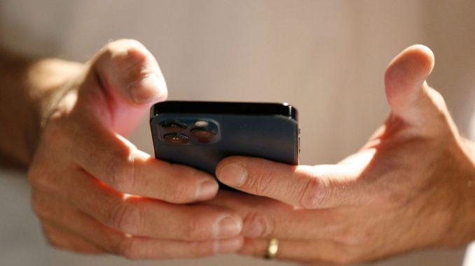 A person scans and downloads an app to start the process of converting their physical driver license to an official digital version to be stored on a mobile phone at a Harmons Grocery store on August 4, 2021 in Salt Lake City, Utah. Utah is the first state in the nation to start to convert and offer digital driver licenses on mobile devices. (Photo by George Frey/Getty Images)