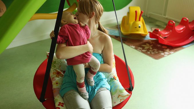 Single mother Nancy Kett, 19, swings with her 11-month-old daughter Lucy in the playroom of the Jule facility for single parents in Marzahn-Hellersdorf district on October 5, 2012 in Berlin, Germany. (Photo by Sean Gallup/Getty Images)