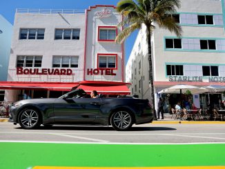 A car drives along Ocean Drive after the city reopened it to one lane of traffic flowing southbound on January 24, 2022 in Miami Beach, Florida. (Photo by Joe Raedle/Getty Images)