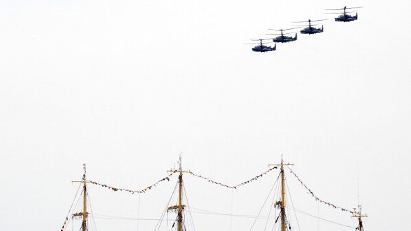 Russian Kamov Ka-52 Alligator attack helicopters fly above the masts of a tall ship in the Crimean port of Sevastopol on May 9, 2014. Helicopters have been a key asset for both Ukraine and Russia in the latest conflict between the two countries.  YURI KADOBN/AFP VIA GETTY IMAGES