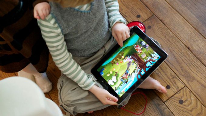 strongA brother, aged 4, and sister, aged 1, play with an iPad and iPhone. (Photo by Mark Makela/Corbis/Getty Images)/strong