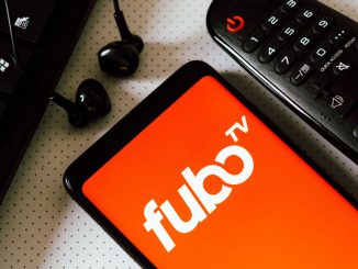 In this photo illustration, the logo of the FuboTV, an American television streaming service seen displayed on a smart phone next a Tv remote control, earphones and a keyboard. FuboTV Inc is a sports-first, live TV streaming company, offering subscribers access to tens of thousands of live sporting events annually as well as news and entertainment content. RAFAEL HENRIQUE/BENZINGA
