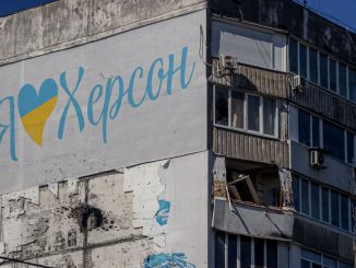A damaged residenial building in the city of Kherson, with the slogan I love Kherson just above a hole from artillery shelling on March 14, 2023, amid the Russian invasion of Ukraine. A story told of local Kherson native helping his community during the times of war.