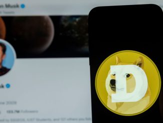 In this photo illustration, Dogecoin logo seen displayed on a mobile phone screen with Elon Musk's Twitter account in the background. Musk has been known to have price flucuations in markets through his tweets. IDREES ABBAS/BENZINGA