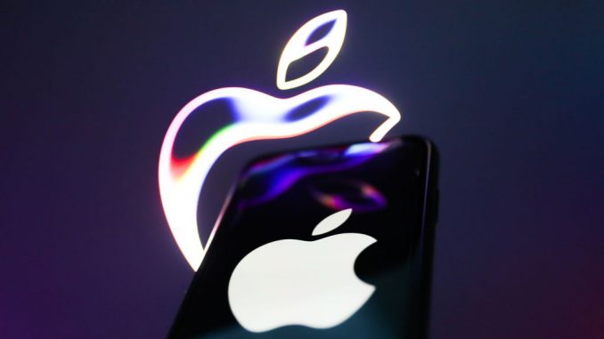 Apple website displayed on a laptop screen and Apple logo displayed on a phone screen (Jakub Porzycki/Benzinga)