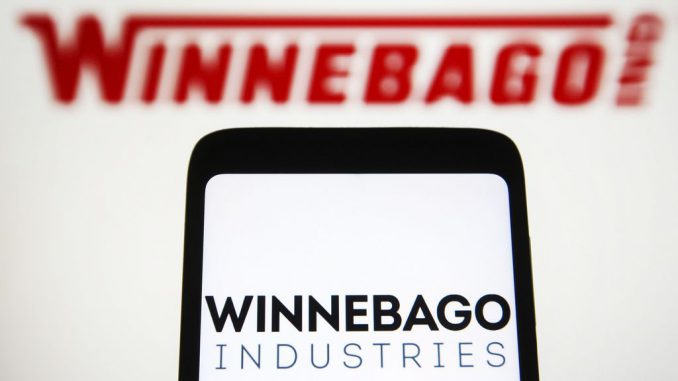 Winnebago Industries Inc. logo is seen on a smartphone screen and in the background.The Solis Pocket 36B system eliminates the need for shore power, powering air conditioning, lighting, water heaters, water pumps, appliances and device recharging.  PAVLO GONCHAR/SOPA IMAGES/LIGHTROCKET VIA GETTY IMAGES. 