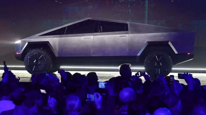 People take pictures of the newly unveiled all-electric battery-powered Tesla's Cybertruck at Tesla Design Center in Hawthorne, California on November 21, 2019.Tesla Cybertruck, Factory Updates And More: Tesla's official Twitter handle shared a photo of the first Cybertruck that rolled off the production line of the Giga Texas, which was surrounded by the factory’s workers. PHOTO BY FREDERIC J.BROWN/GETTY IMAGES