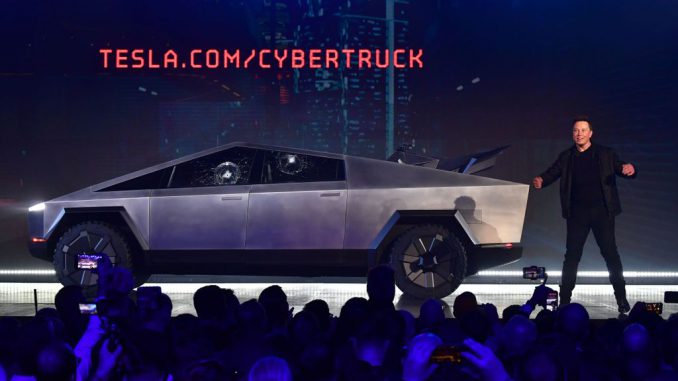 Tesla co-founder and CEO Elon Musk on stage with the newly unveiled all-electric battery-powered Tesla Cybertruck with broken glass on windows following a demonstation that did not quite go as planned on November 21, 2019 at Tesla Design Center in Hawthorne, California. - Tesla introduced a new electric sports utility vehicle slightly bigger and more expensive than its Model 3, pitched as an electric car for the masses. PHOTO BY FREDERIC J.BROWN/GETTY IMAGES