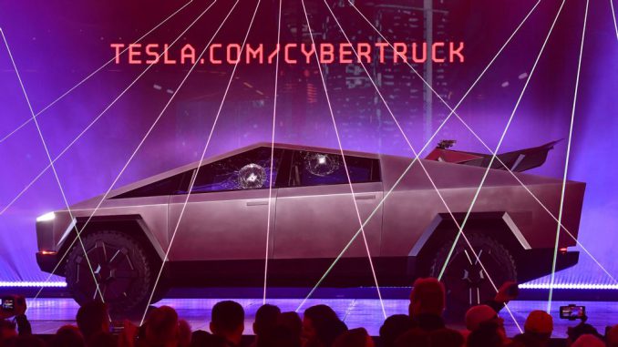 People take pictures of the newly unveiled all-electric battery-powered Tesla's Cybertruck with shattered windows after a failed resistance test, at Tesla Design Center in Hawthorne, California on November 21, 2019. While the Cybertruck has been seen multiple times a href=https://www.Zenger News.com/news/23/07/33192701/elon-musk-says-cybetrucks-camo-wrap-makes-it-practically-invisible-take-a-lookin a camouflage wrap/a, now the electric pickup truck was, recently, seen sporting a darker camo wrap, barely veiling its design details and adding an air of mystery. PHOTO BY FREDERIC J. BROWN/GETTY IMAGES