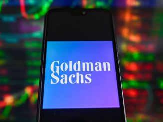 In this photo illustration a Goldman Sachs logo is displayed on a smartphone with stock market percentages in the background. PHOTO BY OMAR MARWUES/GETTY IMAGES