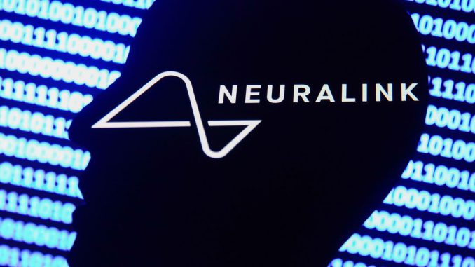 Neuralink logo displayed on a phone screen, a silhouette of a paper in shape of a human face and a binary code displayed on a screen are seen in this multiple exposure illustration photo taken in Krakow, Poland on December 10, 2021. JAKUB PORZYCKI/BENZINGA