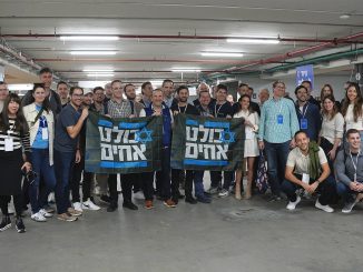 Participants in the December 17-20 Israel Tech Mission from the United States. The banners read, We are all brothers. ISRAEL TECH MISSION.