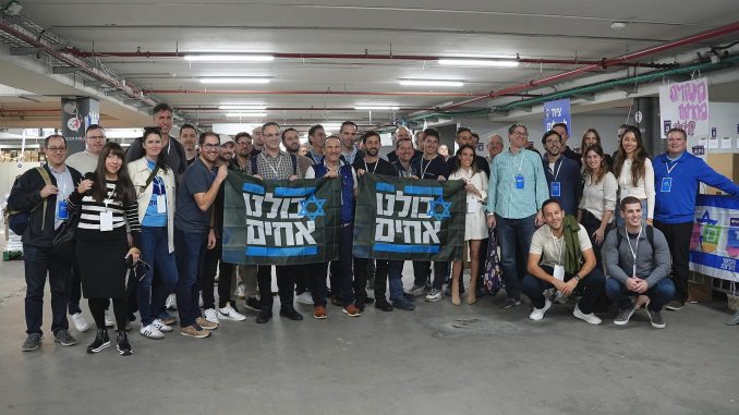 Participants in the December 17-20 Israel Tech Mission from the United States. The banners read, We are all brothers. ISRAEL TECH MISSION.